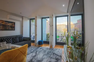 a living room with a couch and large windows at Sunshine Apartment in Porto