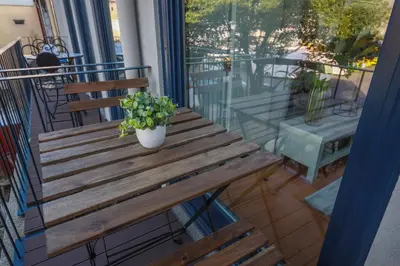 a wooden bench with a potted plant on a balcony at Sunshine Apartment in Porto