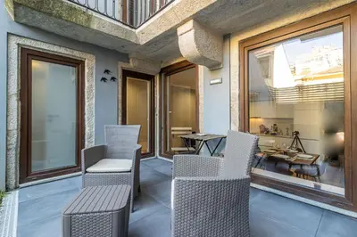 a balcony with chairs and a table and windows at Camellia Garden in Porto