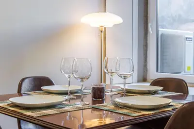 a table with plates and wine glasses on it at Camellia Garden in Porto