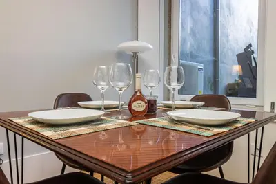 a wooden table with plates and wine glasses on it at Camellia Garden in Porto