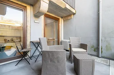 a balcony with chairs and a table and a window at Camellia Garden in Porto