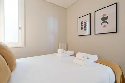 a bedroom with a white bed with towels on it at Habitatio - Aliados by LuxiStay in Porto