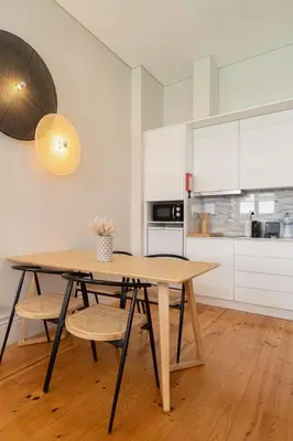 a dining room table with two chairs and a kitchen at Habitatio - Aliados by LuxiStay in Porto