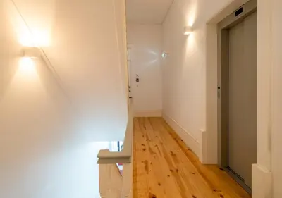 a hallway with white walls and a wooden floor at Habitatio - Aliados by LuxiStay in Porto