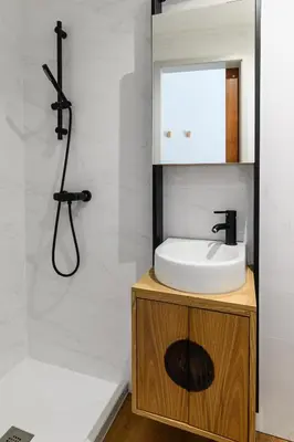 a bathroom with a sink and a mirror and a shower at Maria da Sé Historic House in Porto