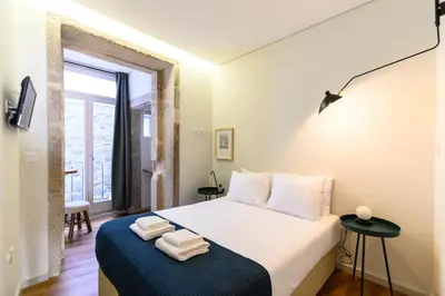 a bedroom with a bed with towels on it at Maria da Sé Historic House in Porto