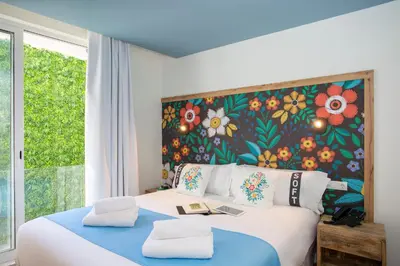 a bedroom with a large bed with a floral wall at Casual Raízes Porto in Porto