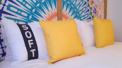 two yellow pillows sitting on top of a bed at Casual Raízes Porto in Porto