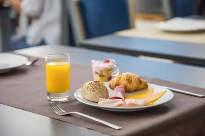 a plate of food and a glass of orange juice at Casual Raízes Porto in Porto