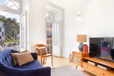 a living room with a blue couch and a tv at InBloom Apartments in Porto