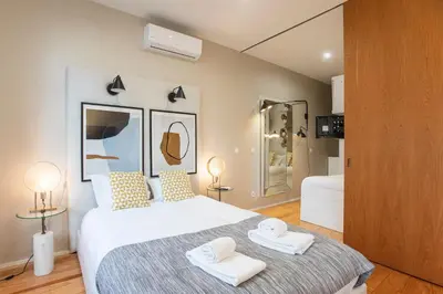 a bedroom with a bed with two towels on it at Cute & Bright Flat w/ AC by LovelyStay in Porto