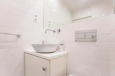 a white bathroom with a sink and a mirror at Cute & Bright Flat w/ AC by LovelyStay in Porto