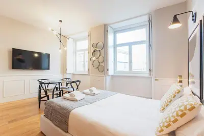 a bedroom with a bed and a table and a tv at Cute & Bright Flat w/ AC by LovelyStay in Porto