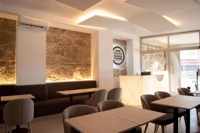 a dining room with wooden tables and chairs at Hotel Porto Interface Trindade By Kavia in Porto