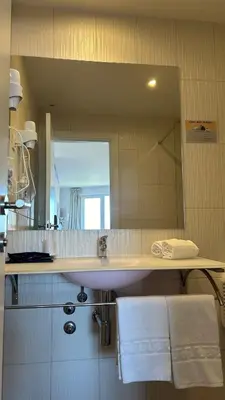 a bathroom with a sink and a mirror at Hotel Porto Interface Trindade By Kavia in Porto