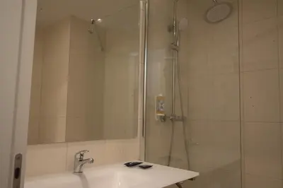 a bathroom with a sink and a shower at Hotel Porto Interface Trindade By Kavia in Porto