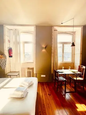 a bedroom with a table and a bed and a dining room at CLUBE Charming Apartments - Cedofeita in Porto