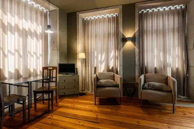 a dining room with a table and chairs and a television at CLUBE Charming Apartments - Cedofeita in Porto