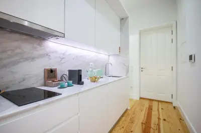 a white kitchen with a counter and a sink at THE TWIN Apartments in Porto