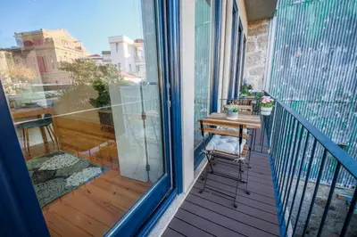 a balcony with a wooden table and a desk at THE TWIN Apartments in Porto