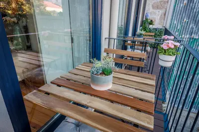 a wooden bench on a balcony with potted plants at THE TWIN Apartments in Porto