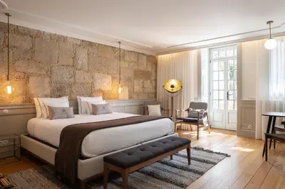 a bedroom with a large bed and a table and chairs at CASA CAMÉLIA in Porto