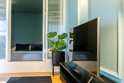 a living room with a television and a plant at Award Winning Design Apt City Center - River View by lisbeyond in Porto