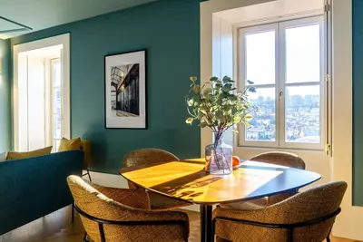 a dining room with a wooden table and chairs at Award Winning Design Apt City Center - River View by lisbeyond in Porto