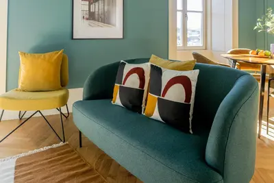 a blue couch with pillows on it in a living room at Award Winning Design Apt City Center - River View by lisbeyond in Porto