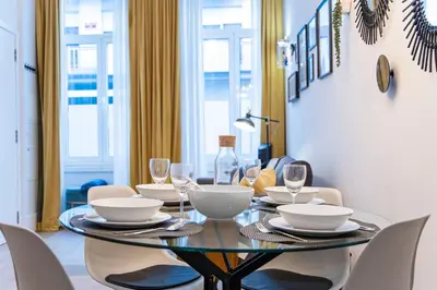 a dining room with a glass table and chairs at Elegant & Bright Flat by LovelyStay in Porto