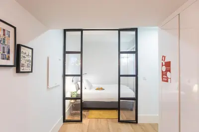 a bedroom with a glass door leading to a bed at Elegant & Bright Flat by LovelyStay in Porto
