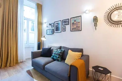 a living room with a blue couch and a window at Elegant & Bright Flat by LovelyStay in Porto