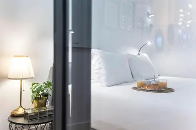a bedroom with a white bed with two glasses of orange juice at Elegant & Bright Flat by LovelyStay in Porto