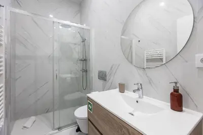 a bathroom with a shower and a sink and a mirror at Elegant & Bright Flat by LovelyStay in Porto