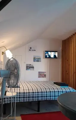a room with a bed and a fan and a tv at Oporto Blue Liberdade - Central Studio with Amazing View and Kitchenette in Porto