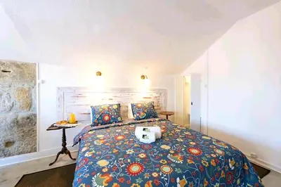 a bedroom with a bed with a colorful comforter at Oporto Blue Liberdade - Central Studio with Amazing View and Kitchenette in Porto