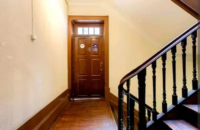 a hallway with a wooden door and stairs at Oporto Blue Aliados - Historic City Center Studio in Porto