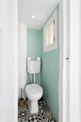 a bathroom with a toilet and a blue wall at Oporto Blue Cedofeita - Charming Citycenter Loft in Porto