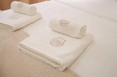 three towels sitting on top of a bed at Gaya Avenue Flats - Elegant Contemporary Flats with Balcony in Vila Nova de Gaia