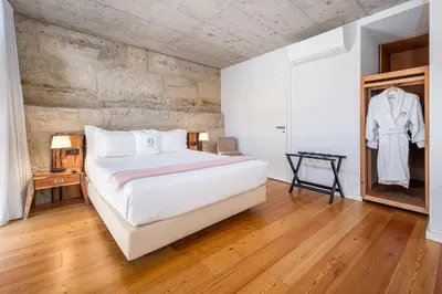 a bedroom with a white bed and a wooden floor at Porta Nobre Boutique Hotel by Aspasios in Porto