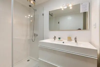 a white bathroom with a sink and a shower at BRA com Apartments Oporto House 68 in Porto