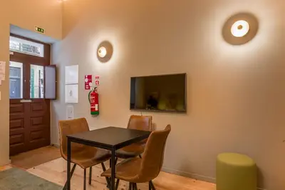 a dining room with a table and chairs and a tv at BRA com Apartments Oporto House 68 in Porto