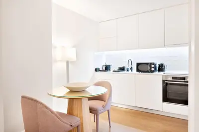 a kitchen with a table and two chairs and a microwave at Catarina Serviced Apartments by HostWise in Porto