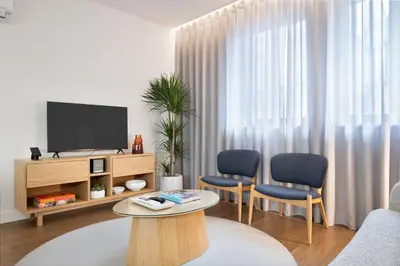 a living room with two chairs and a television at Catarina Serviced Apartments by HostWise in Porto