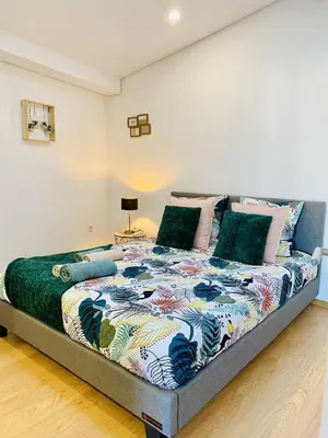 a bedroom with a large bed with a colorful comforter at Douro Eiffel Bridge Amazing View in Vila Nova de Gaia