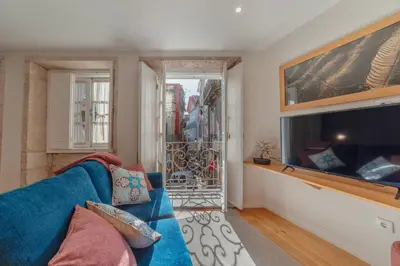 a living room with a blue couch and a large tv at River Eyes at Porto apartments in Porto