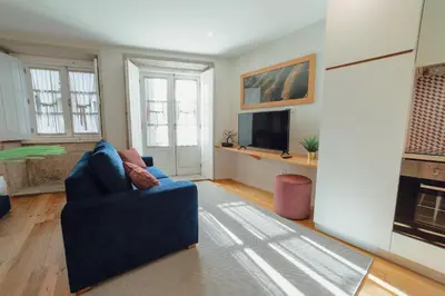 a living room with a blue couch and a tv at River Eyes at Porto apartments in Porto