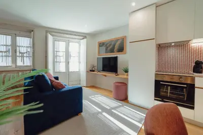 a living room with a blue couch and a tv at River Eyes at Porto apartments in Porto