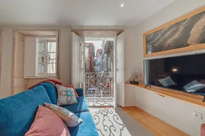 a living room with a blue couch and a tv at River Eyes at Porto apartments in Porto